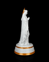 Side view of the statue showing the hooded profile, folded hands, halo, and round base.