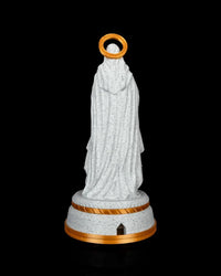 Back view of the statue showing draped robes, halo, round pedestal, and a small opening in the base.