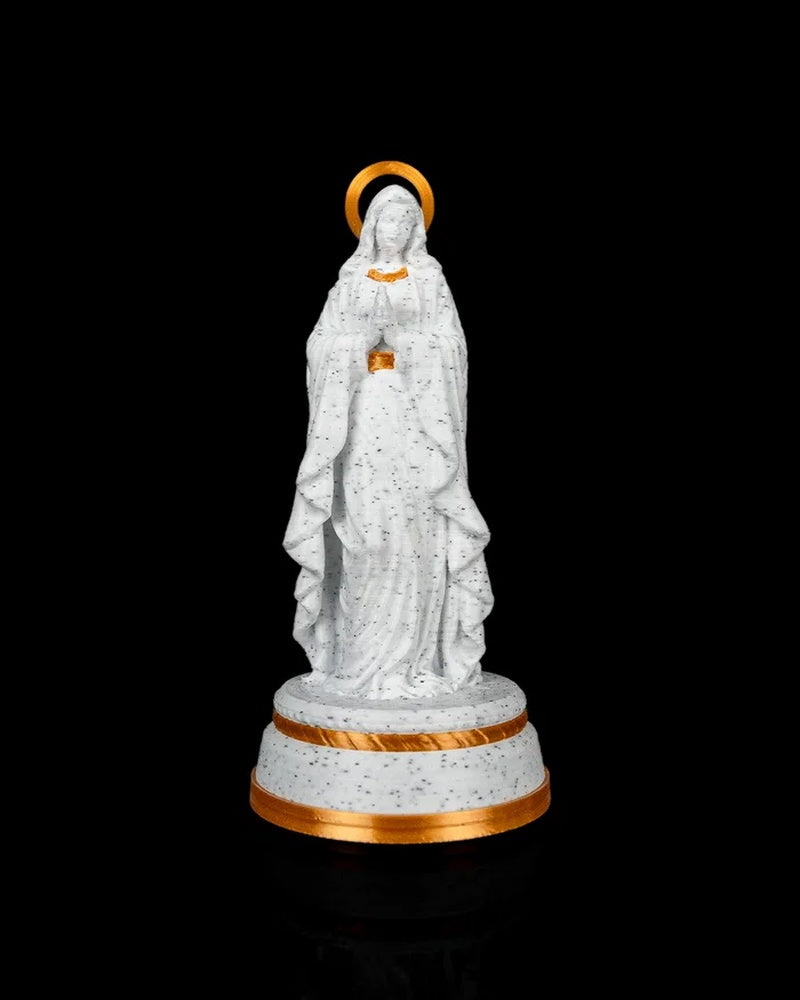 Front view of the white speckled statue with gold-tone halo, accents, and pedestal trim.