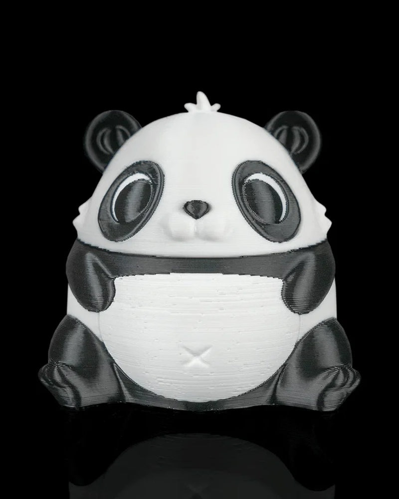 Front view of a rounded black-and-white panda figure on a black reflective surface