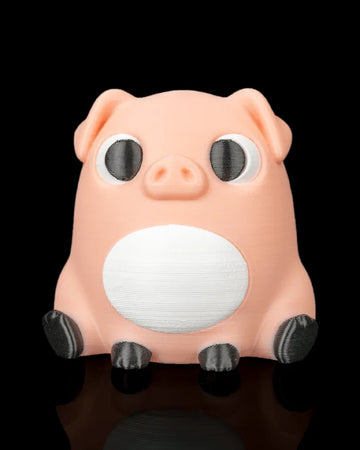 A peach pig figure with black eyes, white belly, floppy ears, and dark hooves sits on a black reflective surface.