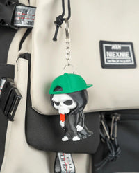 Small hooded skull charm with a green cap hanging from a metal ring on a bag