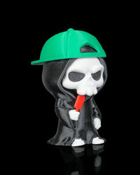 Angled view of a hooded skull figurine wearing a green cap and holding a red pop