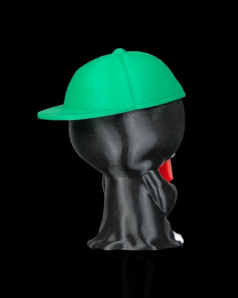 Back view of a hooded skull figurine with a green cap and black robe