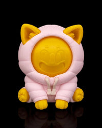 Front view of a yellow dog figurine in a pink hood with raised facial shapes on a black background.