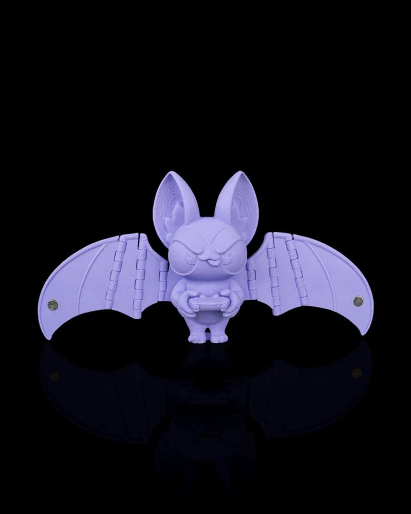 Purple bat figurine with spread wings holding a controller on a black background