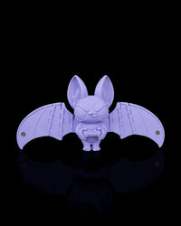 Purple bat figurine with spread wings holding a controller on a black background
