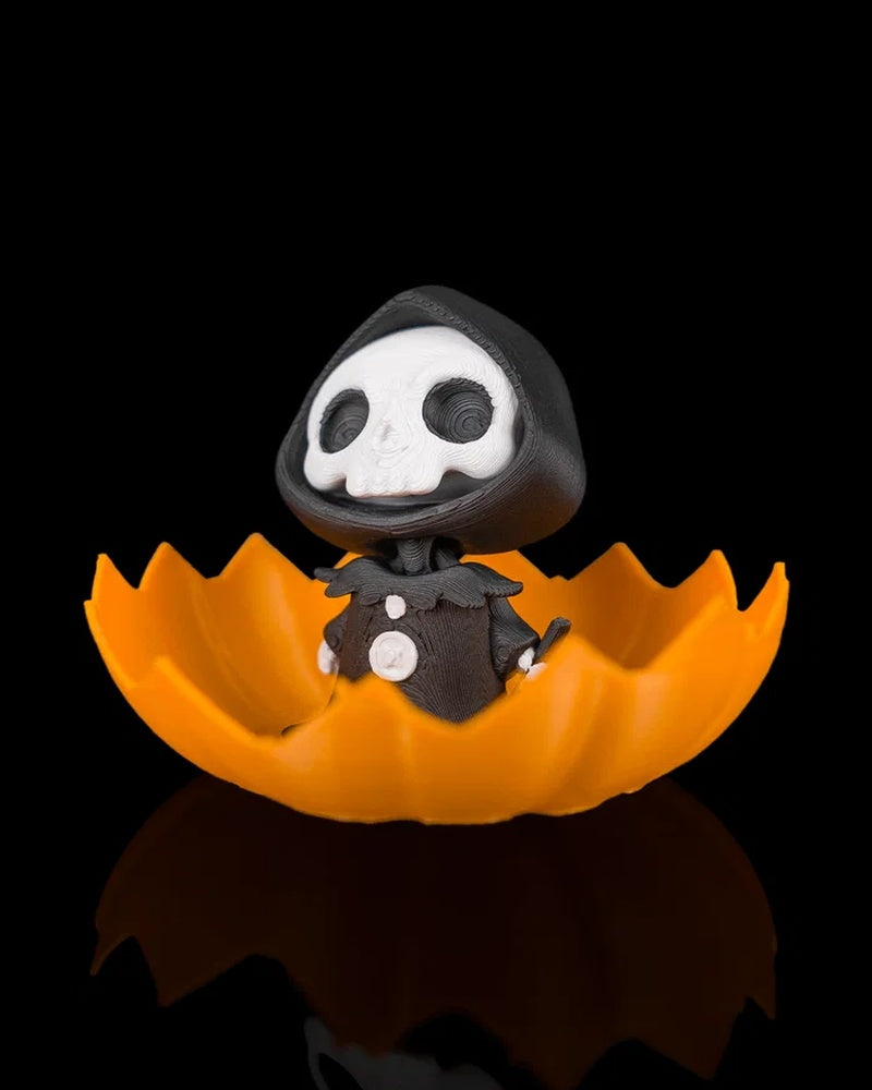 Hooded skull character peeking from a jagged orange pumpkin shell