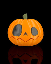 Closed orange pumpkin with dark eyes, small nose, green stem, and jagged mouth