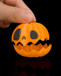 Hand lifting the top of an orange pumpkin with a jagged opening