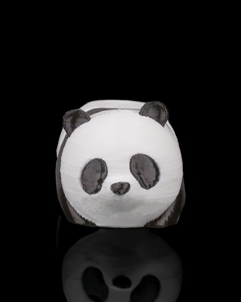 Front view of a black-and-white panda figurine on a dark reflective surface
