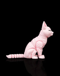 Right side view of a pink cat figurine in a seated pose with large ears, a long tail, and a small fanged smile.