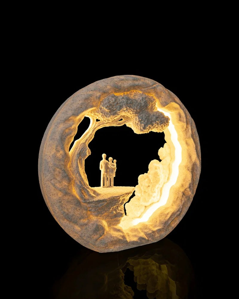 Angled view of a round illuminated scenic lamp with small figures inside