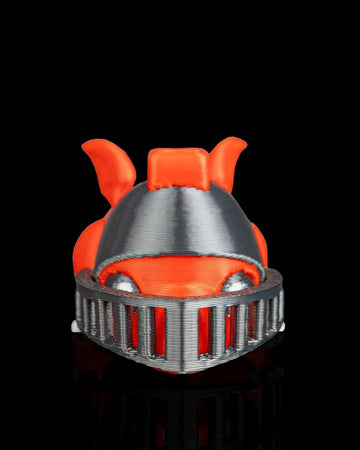 Front view of an orange dragon figurine with a gray helmet and visor on a black reflective surface