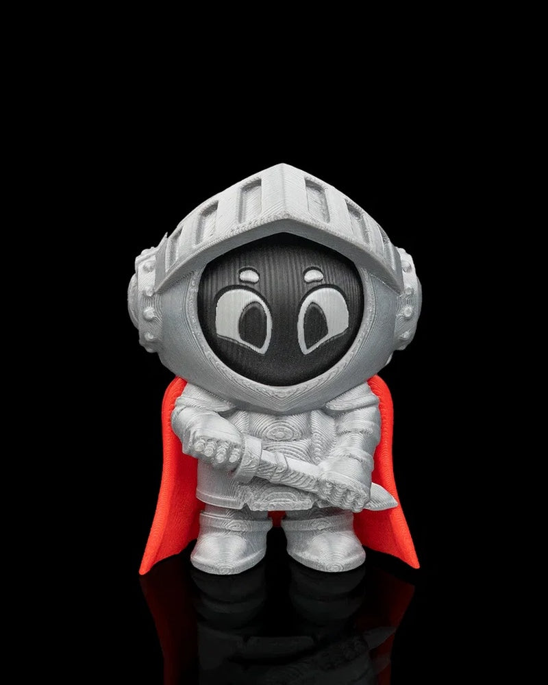 Front view of a silver knight character with wide eyes and red cape on a black background
