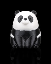Front view of a small black-and-white panda figure on a black background