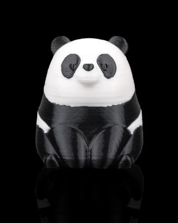 Front view of a small black-and-white panda figure on a black background