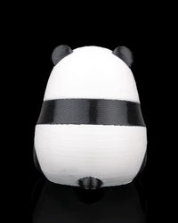 Back view of a small black-and-white panda figure on a black background