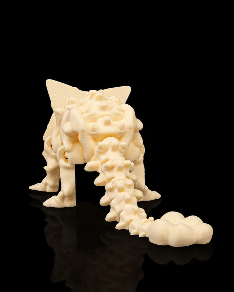 Rear view of cream-colored ankylosaurus skeleton-style figurine showing the tail and back plates