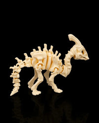 Side view of a cream-colored skeleton dinosaur figurine with a long tail and raised head crest