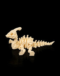 Cream-colored skeleton dinosaur figurine posed low with legs forward and tail extended