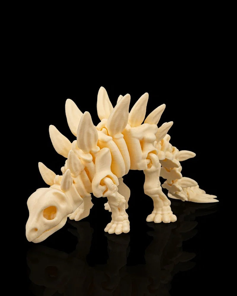 Cream-colored stegosaurus skeleton figurine standing on a glossy black surface
