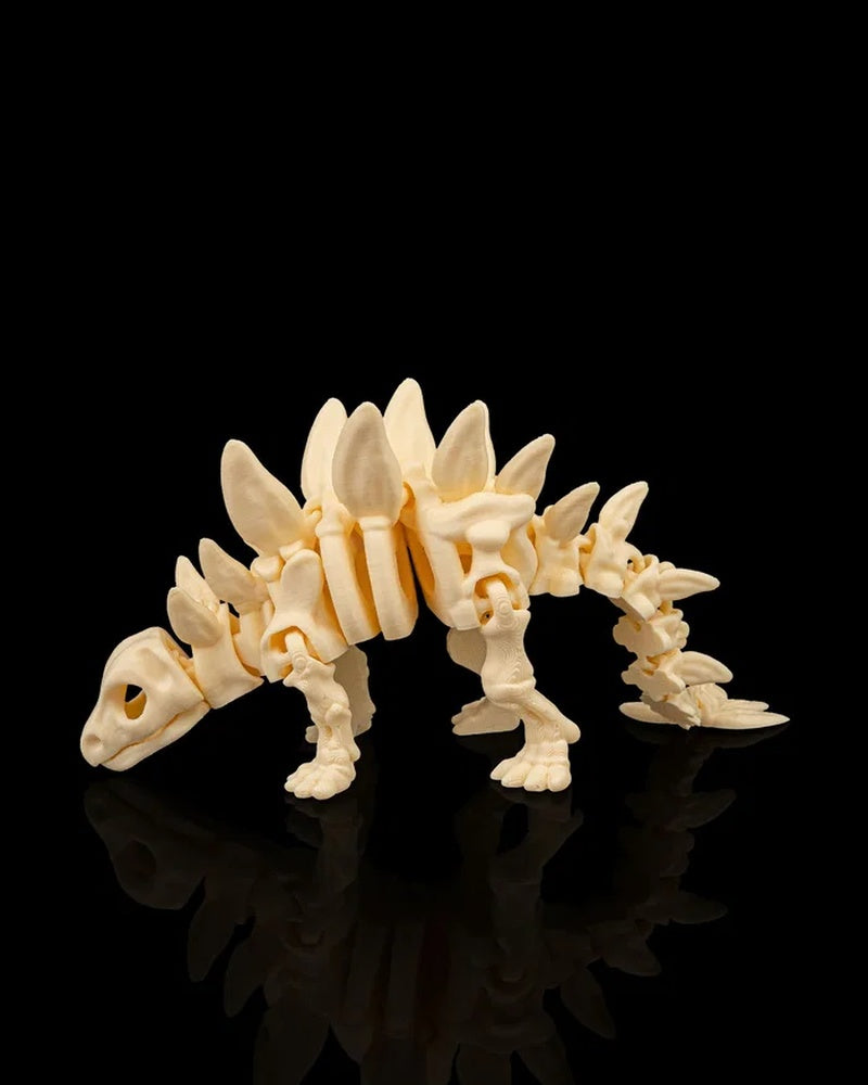 Side view of a cream-colored stegosaurus skeleton figurine with raised back plates