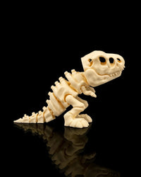 Side view of a cream T-Rex skeleton figurine standing on a black reflective surface