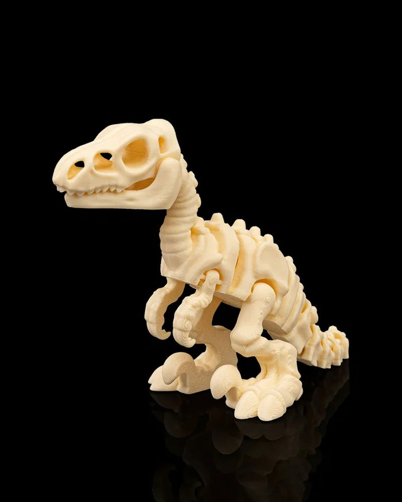 Cream-colored velociraptor skeleton figurine standing on a black reflective surface