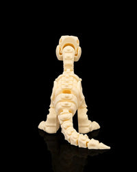 Rear view of a cream-colored velociraptor skeleton figurine with a long segmented tail