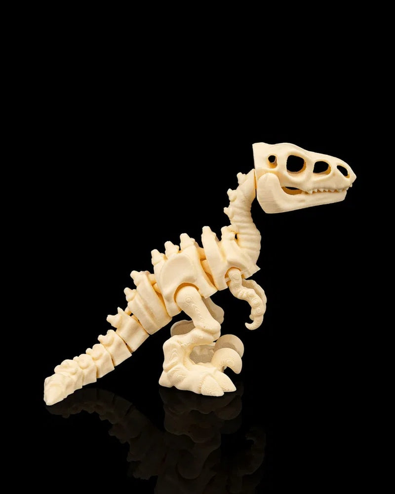 Side view of a cream-colored velociraptor skeleton figurine facing right