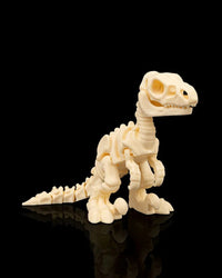 Front angled view of a cream-colored velociraptor skeleton figurine with clawed feet