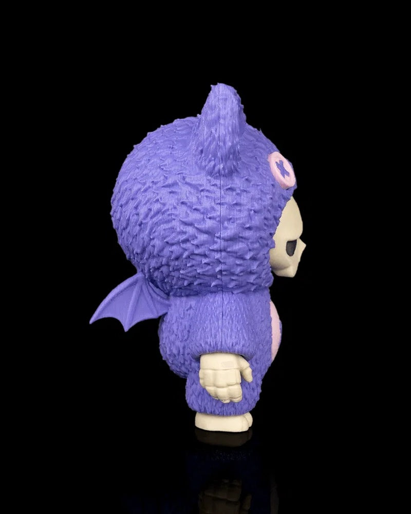 Side view of a purple bat-themed skull figurine with a small wing on its back