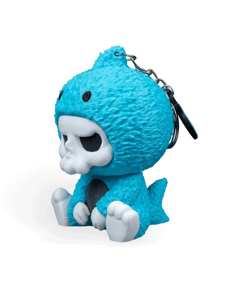 Angled side view of a blue shark costume figurine with a visible metal ring and chain behind the head.