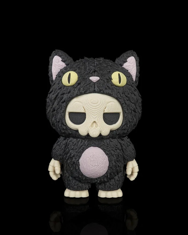 Front view of a black cat skull figurine with yellow eyes, pale skull face, pink ears, and pink belly on a black background