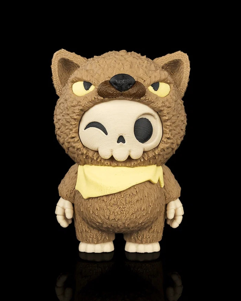 Front view of a brown animal-hood skull figurine with yellow eyes and a yellow scarf on a black background