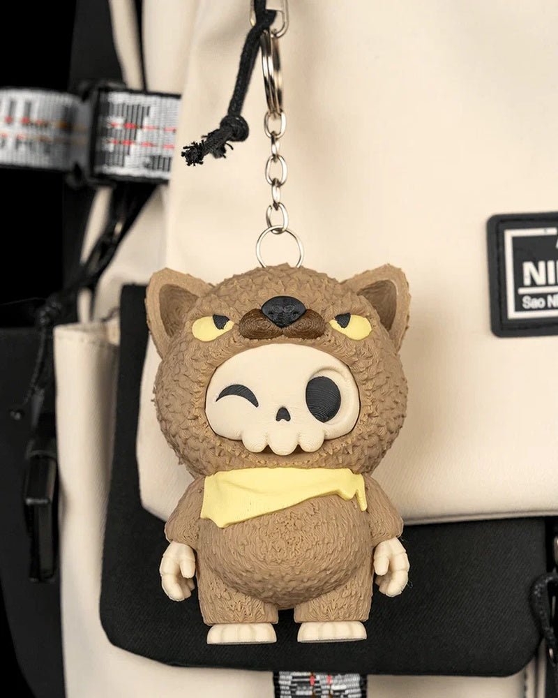 Brown animal-hood skull figurine hanging by a metal ring and chain on a backpack