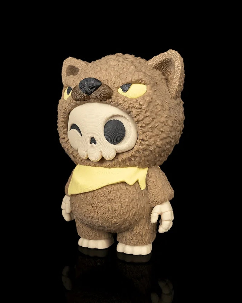 Angled front view of a brown animal-hood skull figurine with a yellow scarf on a black background