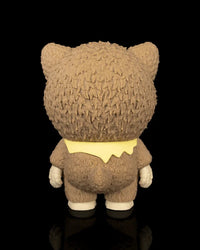 Back view of a brown animal-hood skull figurine with a yellow scarf on a black background