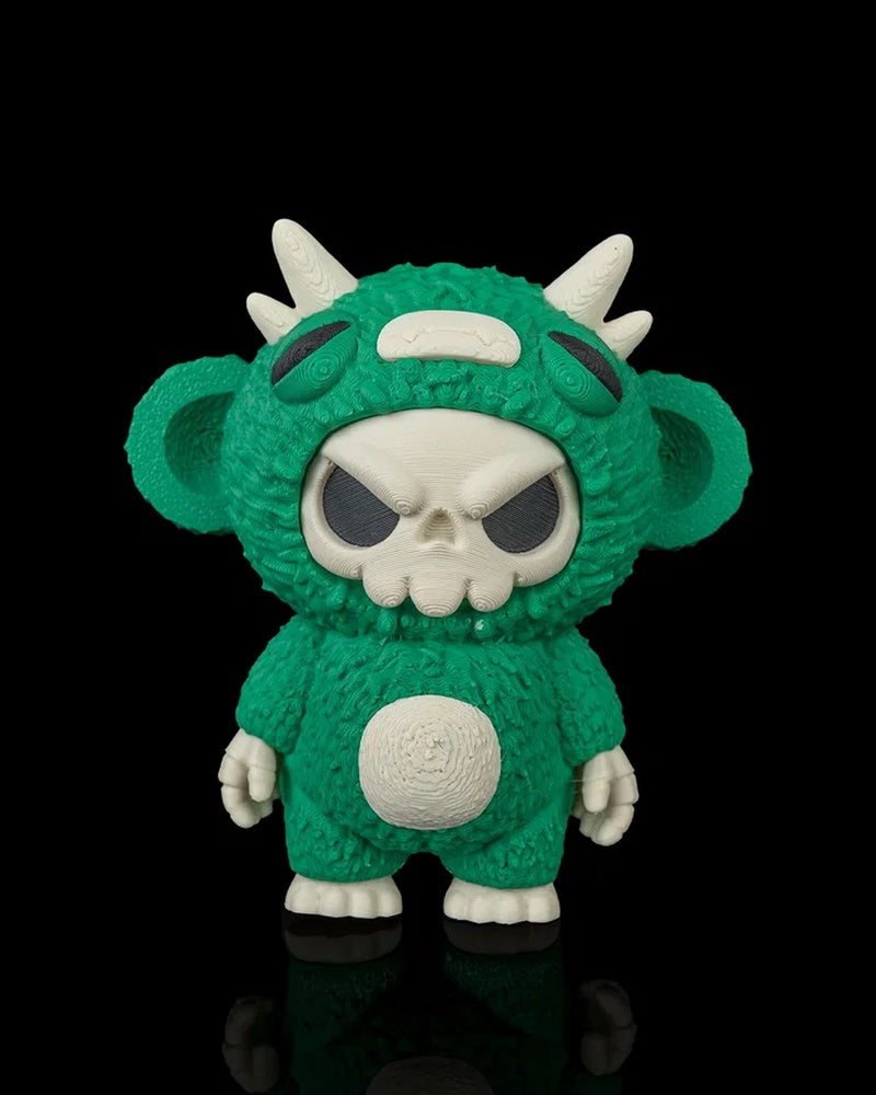 Green skull-faced monster toy with white horns and ears on a black background