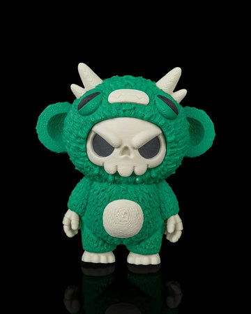 Green skull-faced monster toy with white horns and ears on a black background