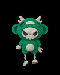 Front view of a green skull-faced monster toy with horns, ears, and white belly detail