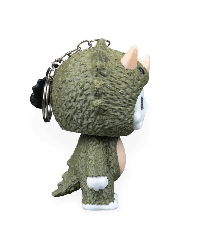 Side rear view of a green horned dinosaur character with a metal ring and chain behind its head.