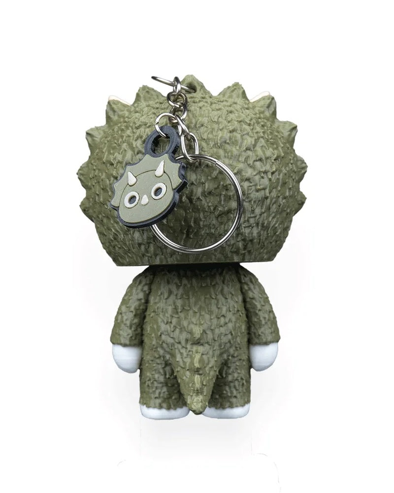 Back view of a green horned dinosaur character with a metal ring and small face charm.