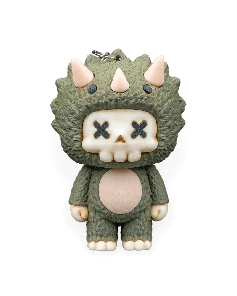 Front view of a green horned dinosaur character with cream skull face, X-shaped eyes, and pale belly.