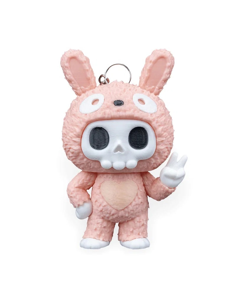 Front view of a pink bunny-suit skull character with tall ears and a raised peace-sign hand