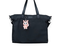 Small pink bunny-suit character hanging from a black bag by a metal ring