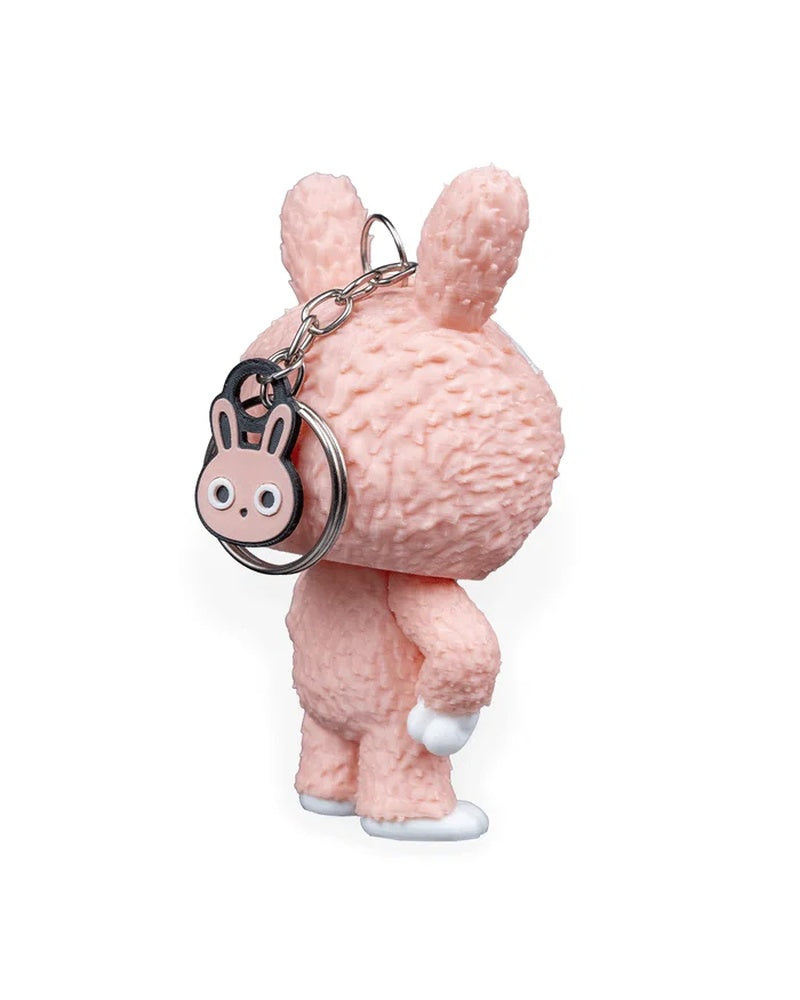 Rear angled view of a pink bunny-suit character with chain, ring, and small bunny charm behind the head