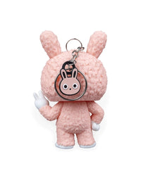 Back view of a pink bunny-suit character with a round ring and bunny charm hanging behind the head
