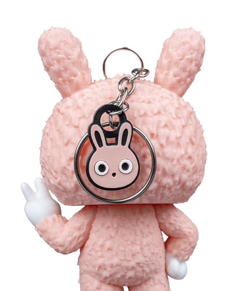 Close back view of a pink bunny-suit character with a round ring and bunny charm near the head